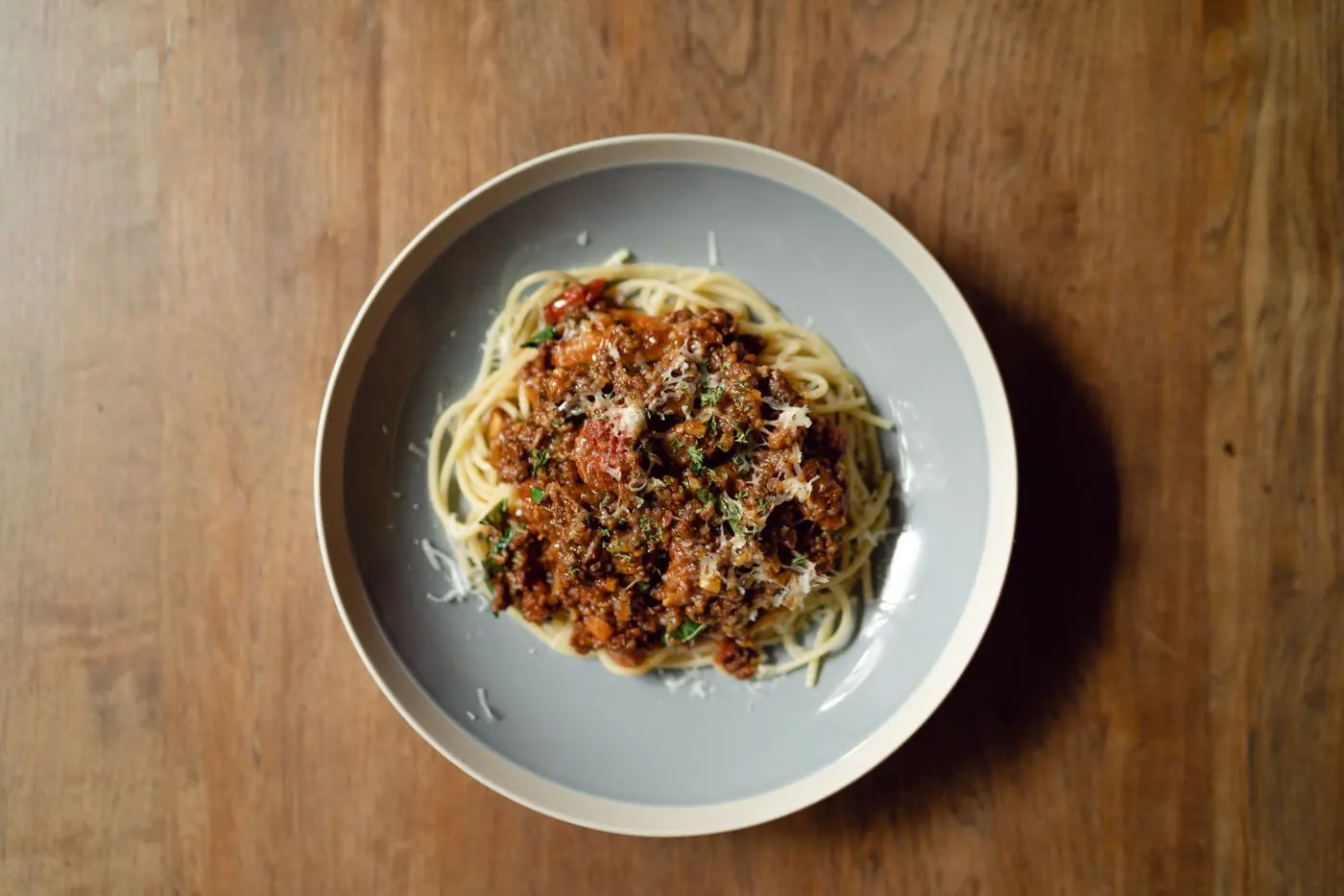 Teller Spaghetti Bolognese mit geriebenem Parmesan von oben