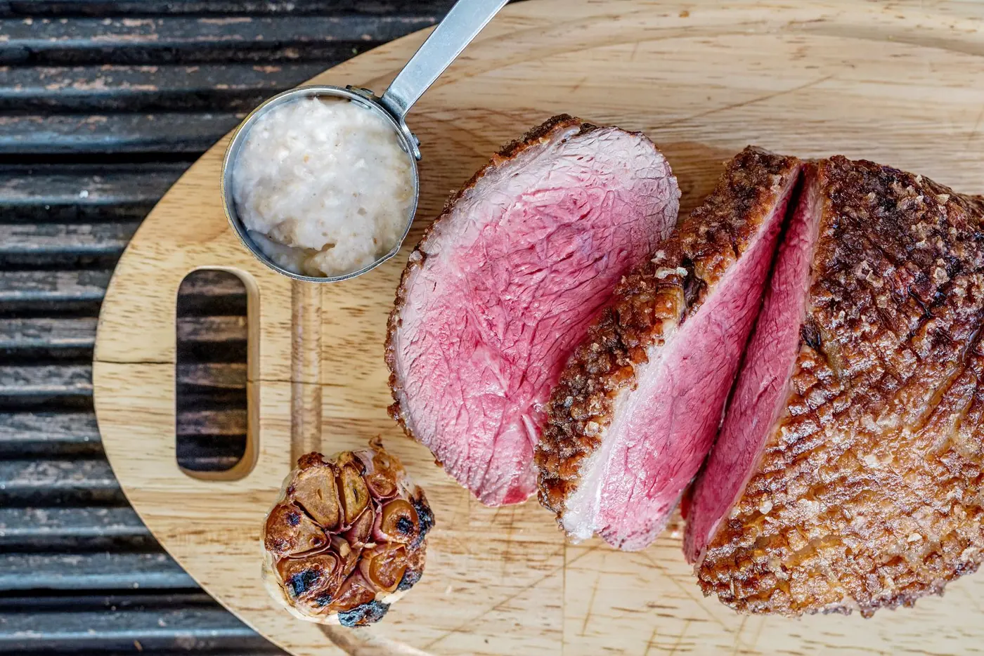 Aufgeschnittener Rinderbraten mit rosa Kern auf einem Holzbrett