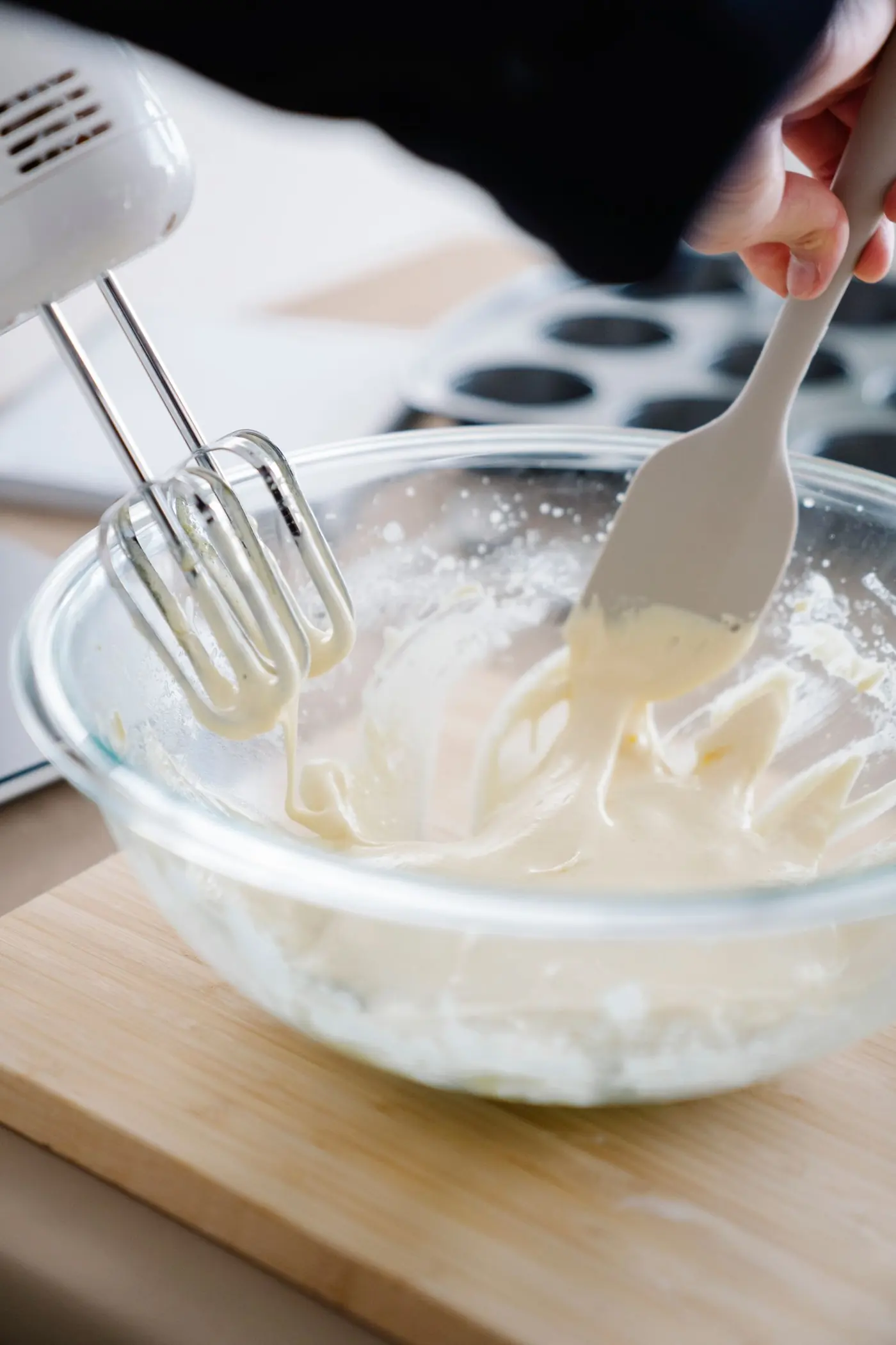 Cremige Käsekuchenmasse wird mit dem Handrührgerät geschlagen