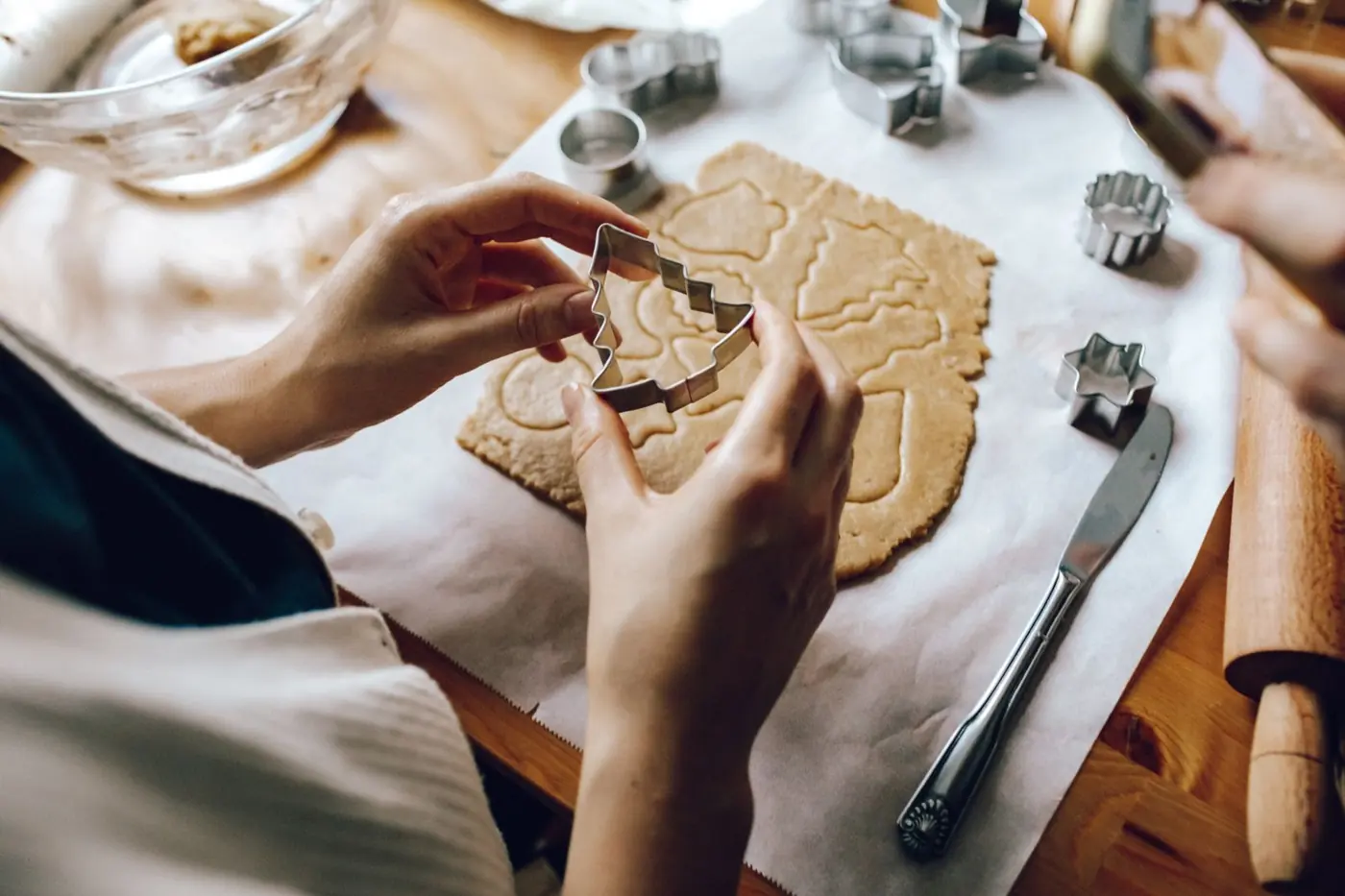 Plätzchen werden mit Förmchen aus ausgerolltem Teig ausgestochen